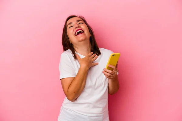 Medelålders Kaukasiska Kvinna Som Håller Mobiltelefon Isolerad Rosa Bakgrund Skrattar — Stockfoto