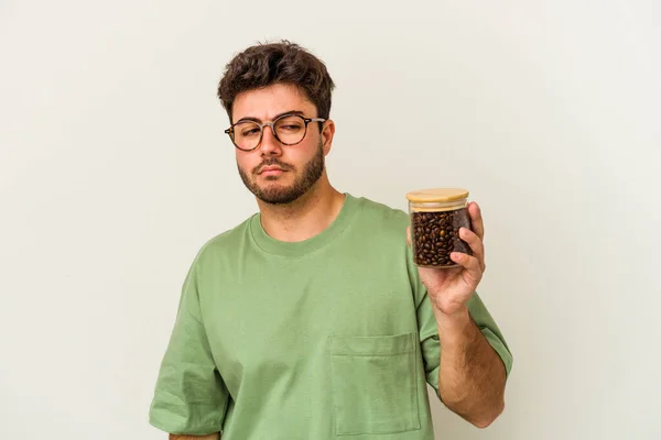 Młody Biały Mężczyzna Trzymający Słoik Kawą Białym Tle Jest Zdezorientowany — Zdjęcie stockowe