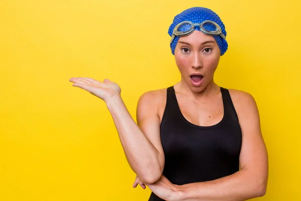 澳大利亚年轻的游泳女子在黄色背景下被隔离 手掌上的复制空间给人留下深刻印象 — 图库照片