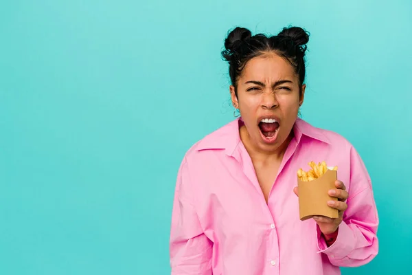 Ung Latinamerikansk Kvinna Håller Chips Isolerade Blå Bakgrund Skriker Mycket — Stockfoto