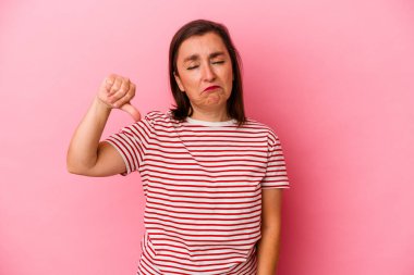 Pembe arka planda soyutlanmış orta yaşlı beyaz bir kadın hoşlanmadığı jestler yapıyor. Anlaşmazlık konsepti.