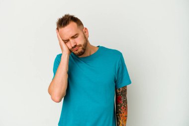 Beyaz arka planda izole edilmiş beyaz dövmeli genç bir adam. Sıkılmış, yorgun ve dinlenmeye ihtiyacı var..