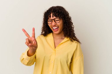 Genç melez kadın beyaz arka planda izole edilmiş. İki numarayı parmaklarıyla gösteriyor..