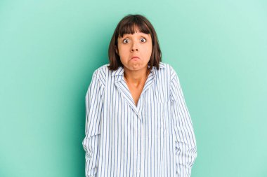 Genç melez kadın mavi omuz silkiyor ve gözleri açık..