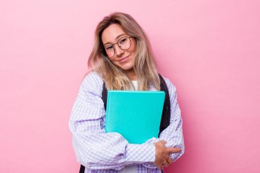 Avustralyalı genç bir öğrenci pembe arka planda izole edilmiş gülüyor ve eğleniyor..