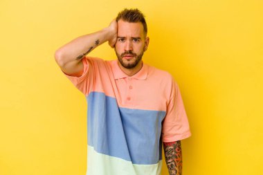 Sarı arka planda izole edilmiş genç dövmeli beyaz adam şok geçiriyordu, önemli bir buluşmayı hatırladı..