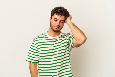 Beyaz arka planda izole edilmiş genç beyaz bir adam bir şeyi unutuyor. Alnına avuç içi ve gözlerini kapayarak vuruyor..