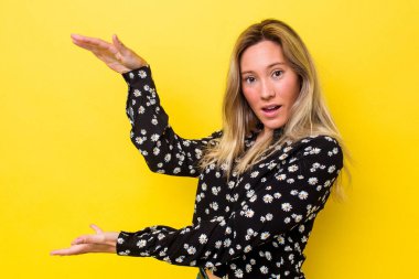 Genç Avustralyalı kadın şok olmuş ve hayrete düşmüş bir şekilde ellerinin arasında bir kopya alanı tutuyor..