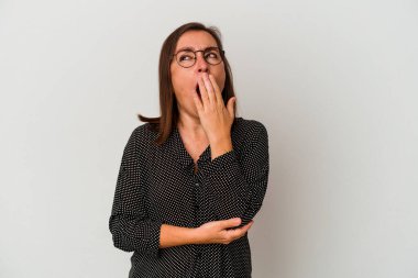 Beyaz arka planda izole edilmiş orta yaşlı beyaz kadın esniyor. Ağzı eliyle kapatan yorgun bir hareket sergiliyor..