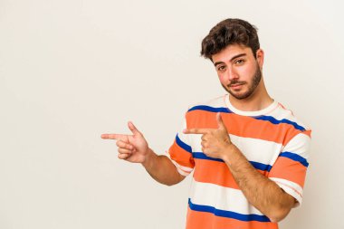 Beyaz arka planda izole edilmiş genç beyaz bir adam işaret parmağıyla fotokopi alanını işaret ederek heyecan ve arzusunu ifade ediyor..