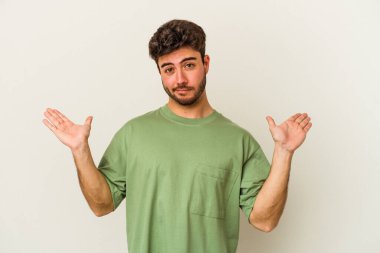 Beyaz arka planda izole edilmiş genç beyaz bir adam. Kafası karışmış ve omuz silkiyor. Kopya alanını tutmak için..