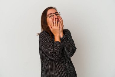 Beyaz arka planda izole edilmiş orta yaşlı beyaz kadın bir şeye gülüyor, elleri ağızda..