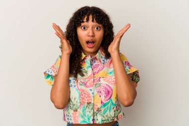 Genç melez kadın beyaz arka planda izole edilmiş şaşırmış ve şok olmuş..