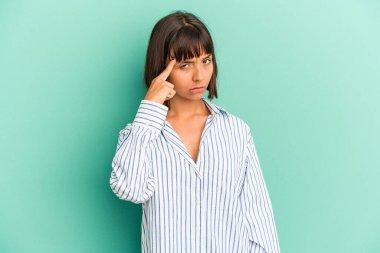 Genç melez kadın, mavi işaret eden bir tapınakta, parmağıyla, düşünerek, bir göreve odaklanmış olarak izole edildi..