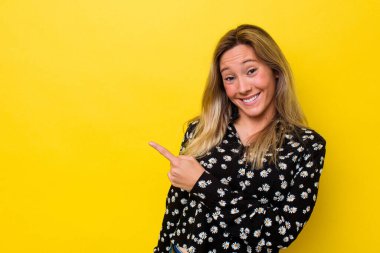 Avustralyalı genç bir kadın kendini soyutlamış gülümsüyor ve boş alanda bir şeyler gösteriyor..