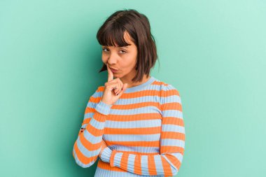 Genç melez kadın mavi ırktan soyutlanmış mavi arka planda izole edilmiş zafer, tutku ve coşkuyu kutlayan mutlu bir ifade..