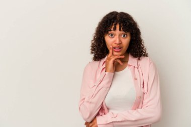 Beyaz arka planda izole edilmiş genç melez kadın şüpheli ve şüpheci bir ifadeyle yana bakıyor..