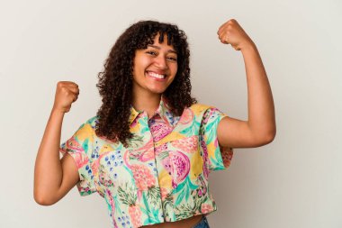 Genç melez kadın beyaz arka planda izole edilmiş tasasız ve heyecanlı bir şekilde tezahürat yapıyor. Zafer konsepti.