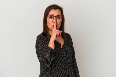 Beyaz arka planda izole edilmiş orta yaşlı beyaz kadın ya sır saklıyor ya da sessizlik istiyor..