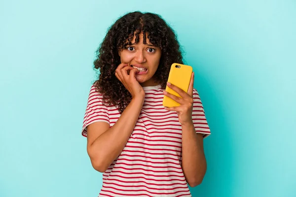 Ung Blandras Kvinna Som Håller Mobiltelefon Isolerad Blå Bakgrund Bita — Stockfoto