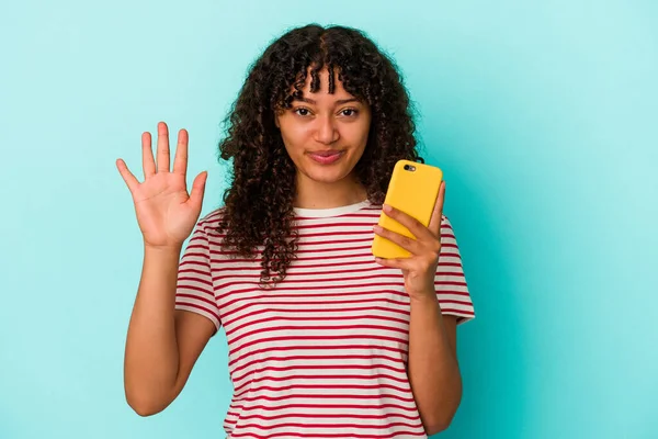 Jovem Mista Segurando Telefone Celular Isolado Fundo Azul Sorrindo Alegre — Fotografia de Stock