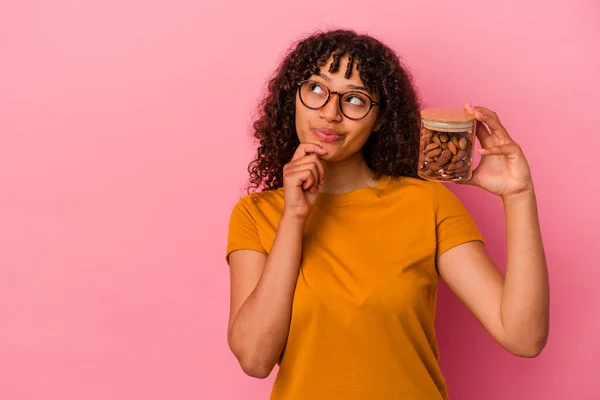 Jovem Mulher Raça Mista Segurando Frasco Amêndoa Isolado Fundo Rosa — Fotografia de Stock