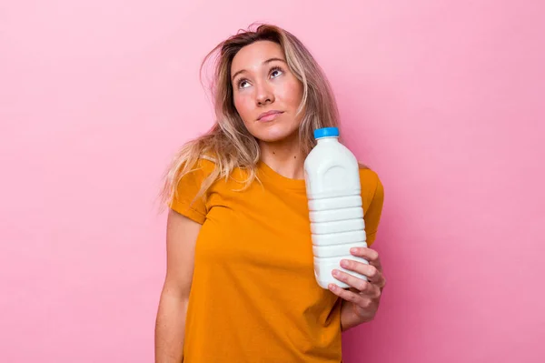 Junge Australierin Hält Eine Flasche Milch Isoliert Auf Rosa Hintergrund — Stockfoto