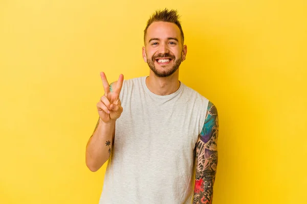 Mladý Tetovaný Běloch Izolovaný Žlutém Pozadí Ukazující Číslo Dvě Prsty — Stock fotografie