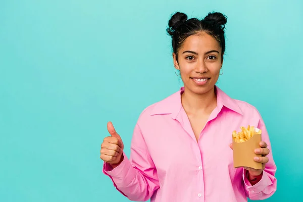 Ung Latinamerikansk Kvinna Håller Chips Isolerad Blå Bakgrund Ler Och — Stockfoto