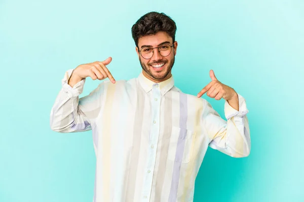 Junger Kaukasischer Mann Auf Blauem Hintergrund Überrascht Mit Erhobenem Zeigefinger — Stockfoto