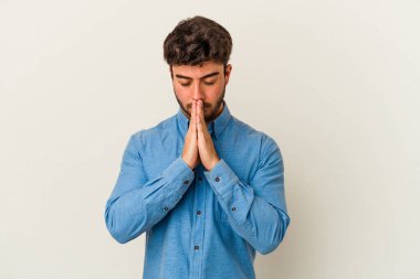 Beyaz arka planda izole edilmiş genç beyaz adam dua ediyor, bağlılık gösteriyor, dindar biri ilahi ilham arıyor..
