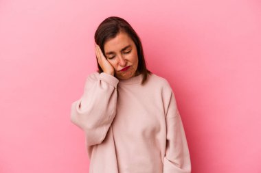 Pembe arka planda soyutlanmış orta yaşlı, yorgun ve dinlenmeye ihtiyacı olan beyaz bir kadın..