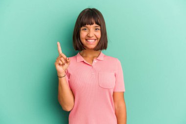 Mavi üzerine izole edilmiş genç melez kadın bir numarayı parmağıyla gösteriyor..