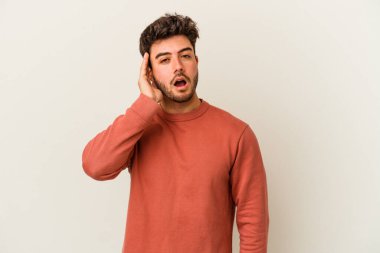 Beyaz arka planda izole edilmiş genç beyaz adam bir dedikoduyu dinlemeye çalışıyor..