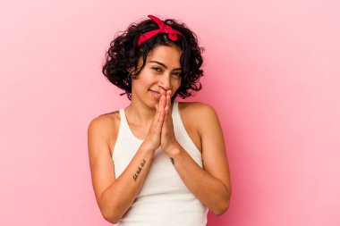 Genç kıvırcık Latin kadın pembe arka planda izole edilmiş enerjik ve rahat hissediyor, ellerini ovuşturuyor kendinden emin..