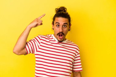 Sarı arka planda izole edilmiş uzun saçlı beyaz bir adam. Harika bir fikri var, yaratıcılık kavramı..