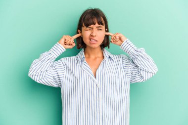 Genç melez kadın mavi kulaklarla izole edilmiş parmaklarıyla stresli ve çaresiz bir ortam tarafından..