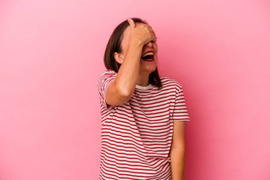 Pembe arka planda soyutlanmış orta yaşlı beyaz bir kadın ellerini başının üstünde tutarak neşe içinde gülüyor. Mutluluk kavramı.