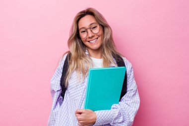Genç Avustralyalı bir öğrenci pembe arka planda izole edilmiş mutlu, gülümseyen ve neşeli..