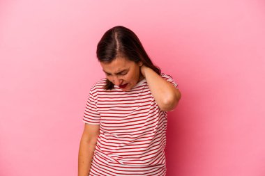 Pembe arka planda izole edilmiş orta yaşlı beyaz kadın stresten dolayı boynu ağrıyor, masaj yapıyor ve elle dokunuyor..