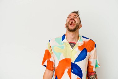 Beyaz arka planda izole edilmiş genç dövmeli beyaz bir adam çok kızgın, öfkeli, hayal kırıklığına uğramış.