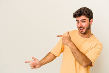 Beyaz arka planda izole edilmiş genç beyaz bir adam işaret parmağıyla işaret ettiği için heyecanlı..