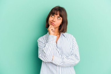 Genç melez kadın mavi düşüncelere dalıp yukarı bakıyor, yansıtıyor, düşünüyor, hayal kuruyor..