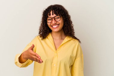 Beyaz arka planda izole edilmiş genç bir ırk kadını selamlama jesti olarak kameraya elini uzatıyor..