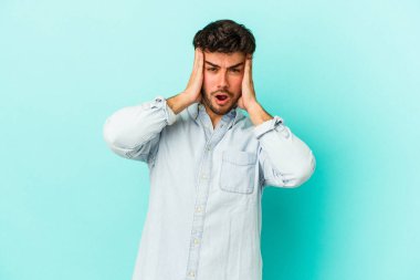 Mavi arka planda izole genç beyaz adam şok oldu, o önemli bir toplantı hatırladı.