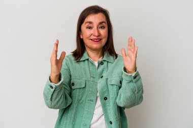 Beyaz arka planda izole edilmiş orta yaşlı beyaz bir kadın. Elinde parmakları olan, gülümseyen ve kendinden emin bir şey var..