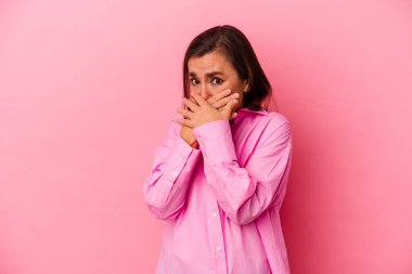 Orta yaşlı beyaz kadın pembe arka planda izole edilmiş ağzı kapalı ve elleri endişeli görünüyor..