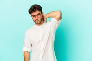 Kafkasyalı genç bir adam mavi arka planda izole edilmiş. Durağan yaşam tarzından dolayı boyun ağrısı çekiyor..