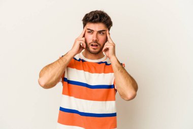 Beyaz arka planda izole edilmiş genç beyaz bir adam parmaklarıyla kulaklarını kapatıyor, gürültülü bir ortam yüzünden stresli ve çaresiz..