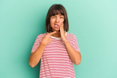 Mavi üzerine izole edilmiş genç bir kadın. Güçlü bir diş ağrısı, azı dişi ağrısı var..